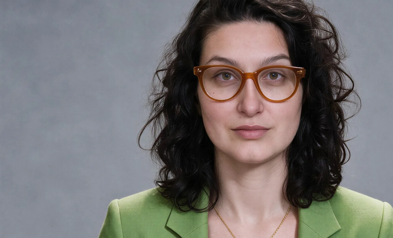 Marja Amim wearing a green blazer and glasses